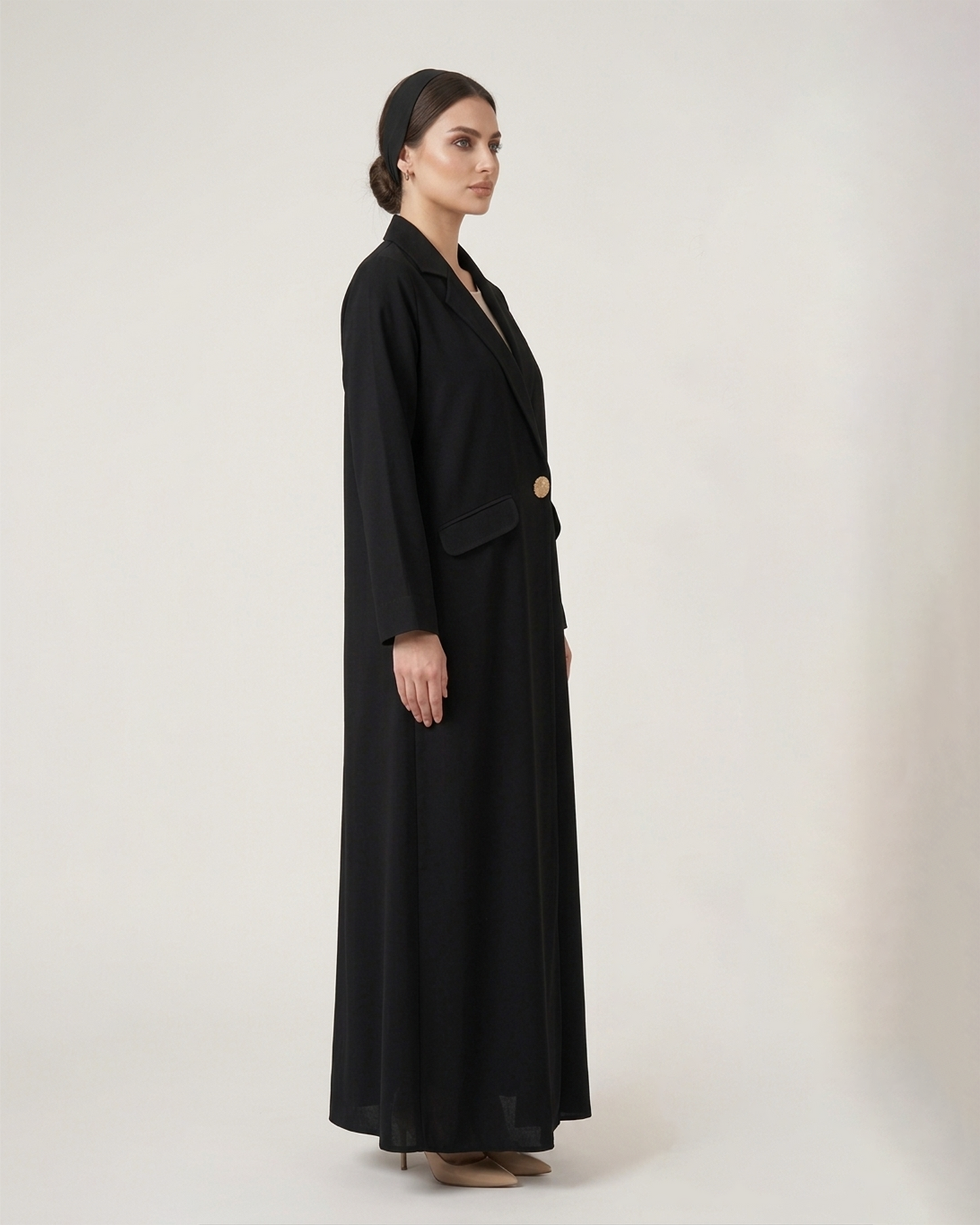 Woman wearing a black long coat on a white background