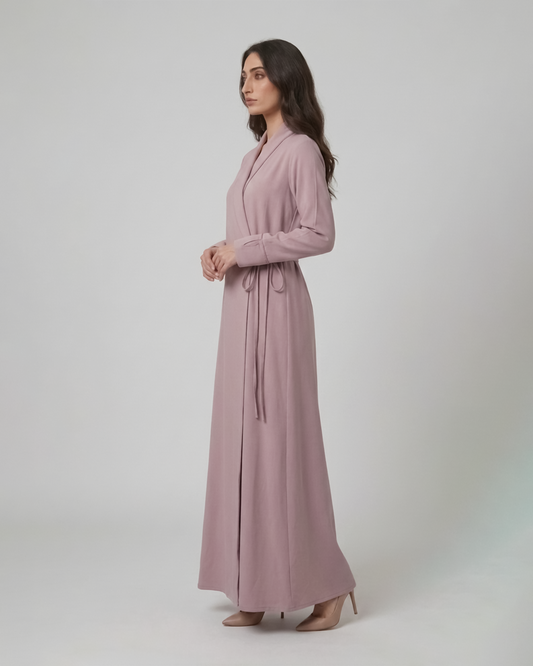 Woman wearing a long pink dress against a white background