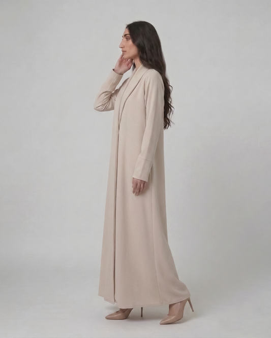 Woman wearing a long beige coat against a white background