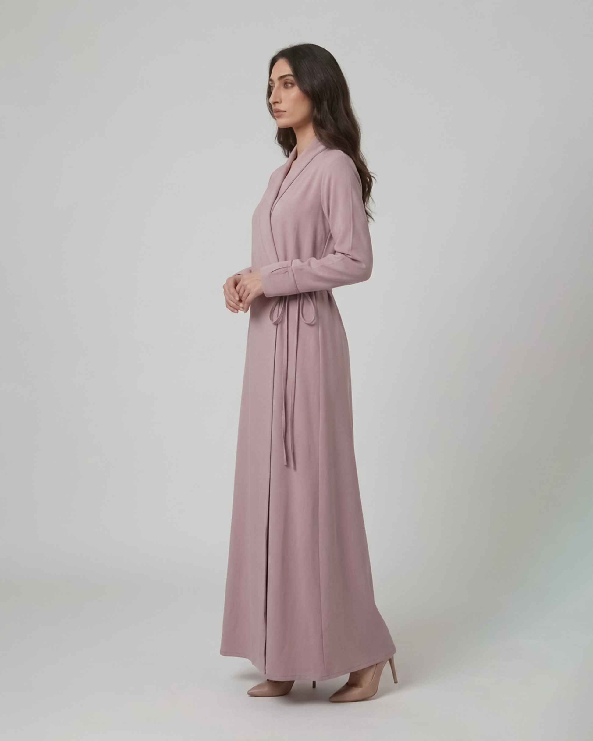 Woman wearing a long pink dress against a white background