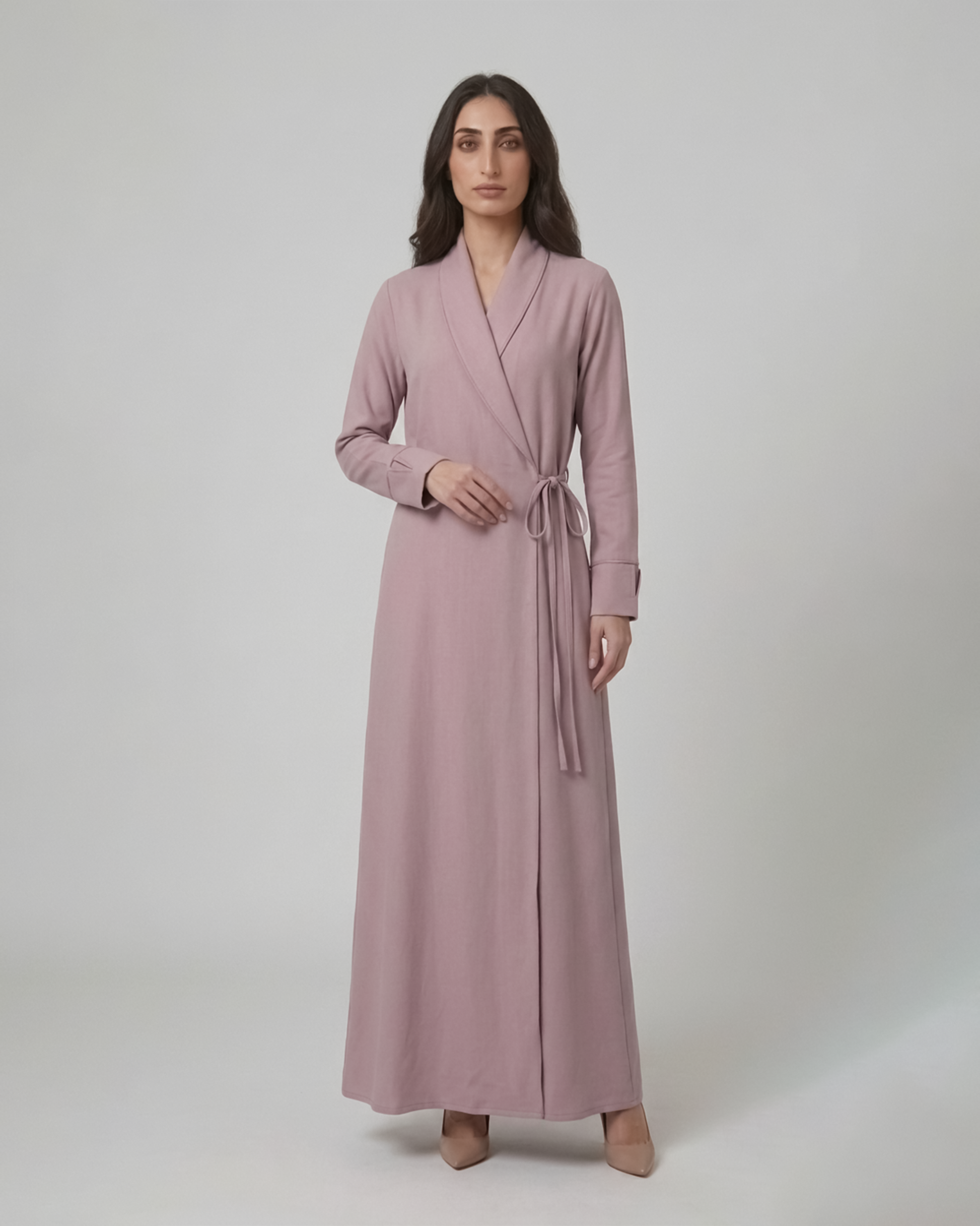 Woman wearing a long pink dress against a white background