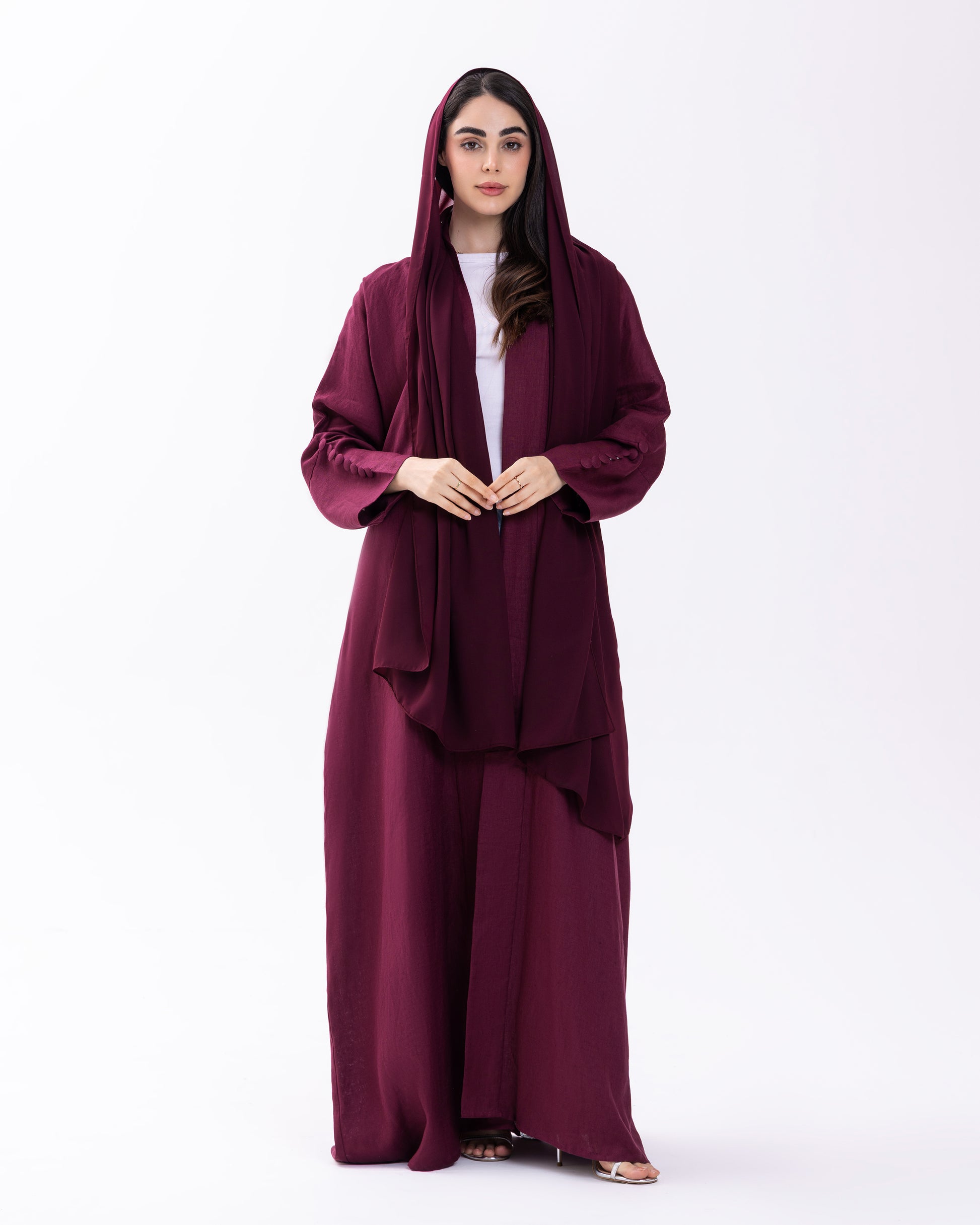 Woman wearing a burgundy abaya on a white background