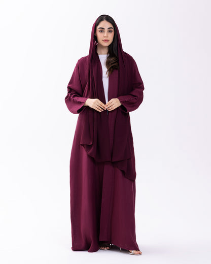 Woman wearing a burgundy abaya on a white background