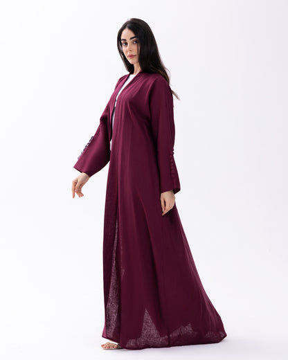 Woman wearing a burgundy abaya on a white background
