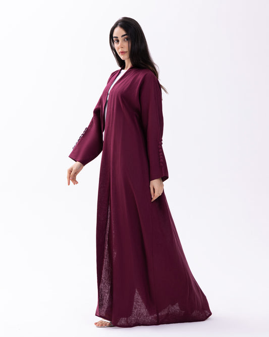Woman wearing a burgundy abaya on a white background
