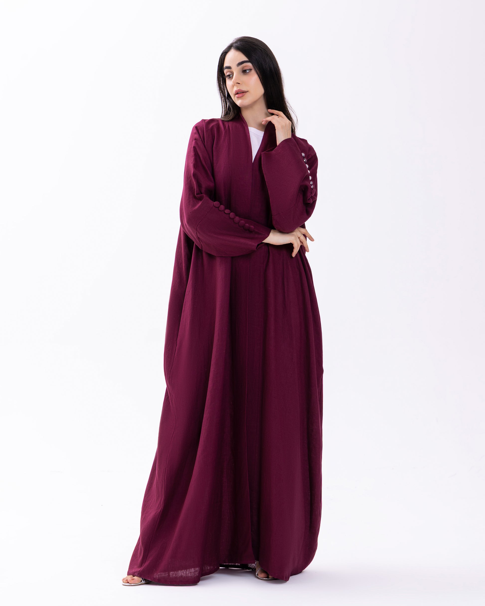 Woman wearing a burgundy abaya on a white background