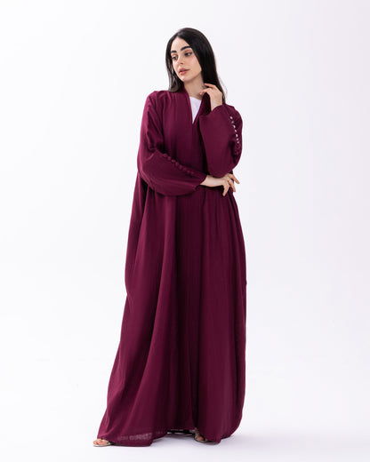 Woman wearing a burgundy abaya on a white background