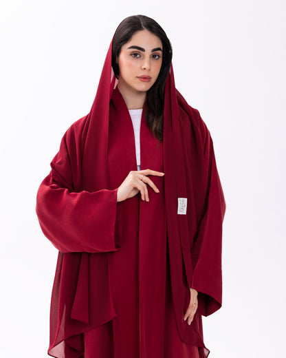 Woman wearing a red abaya on a white background