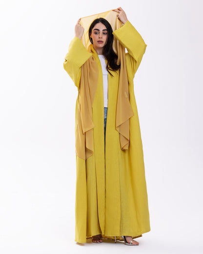 Woman wearing a yellow abaya with a white background