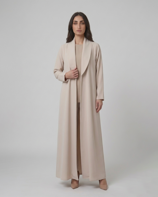 Woman wearing a long beige coat on a plain background