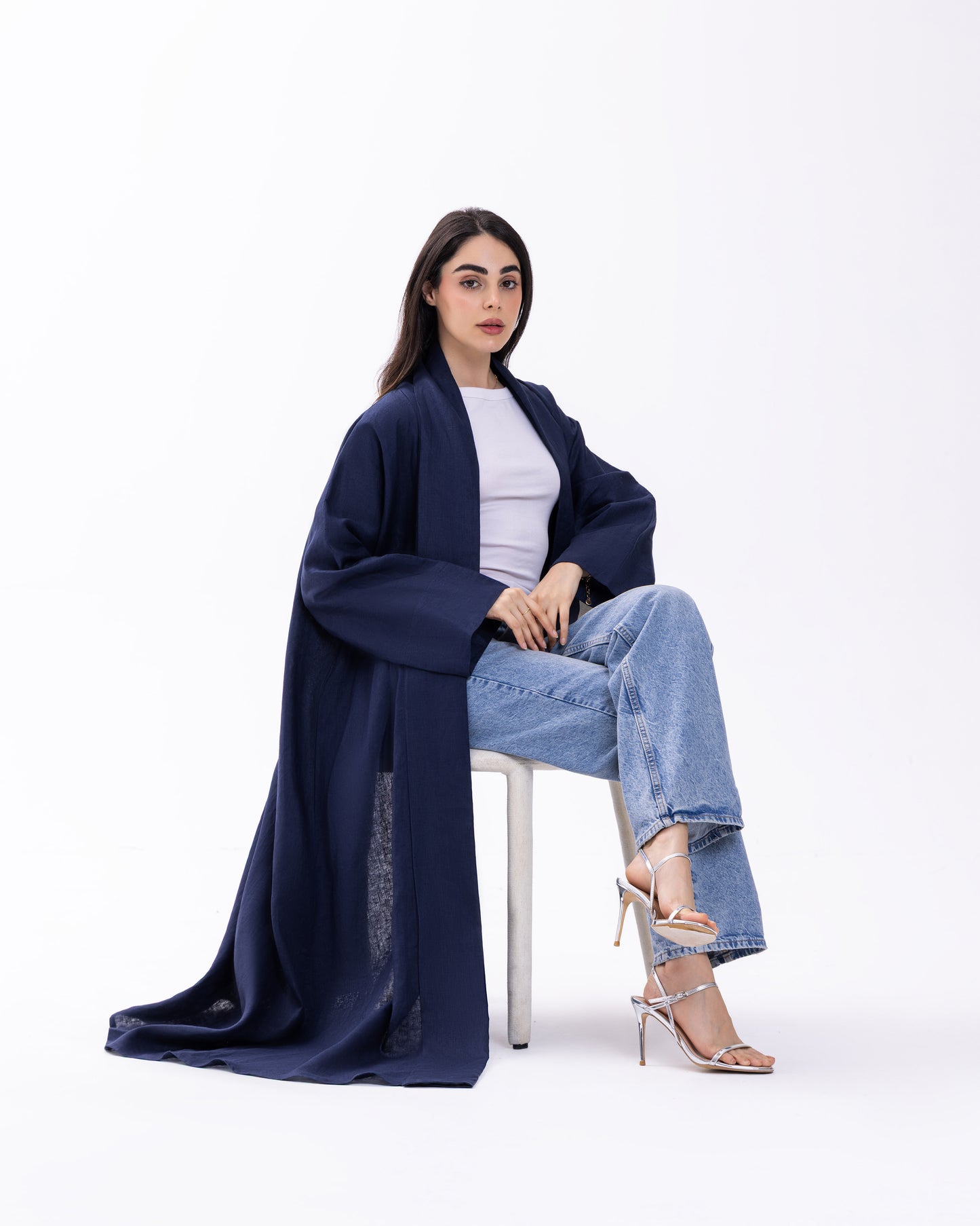 Woman wearing a navy blue kimono-style garment on a white background