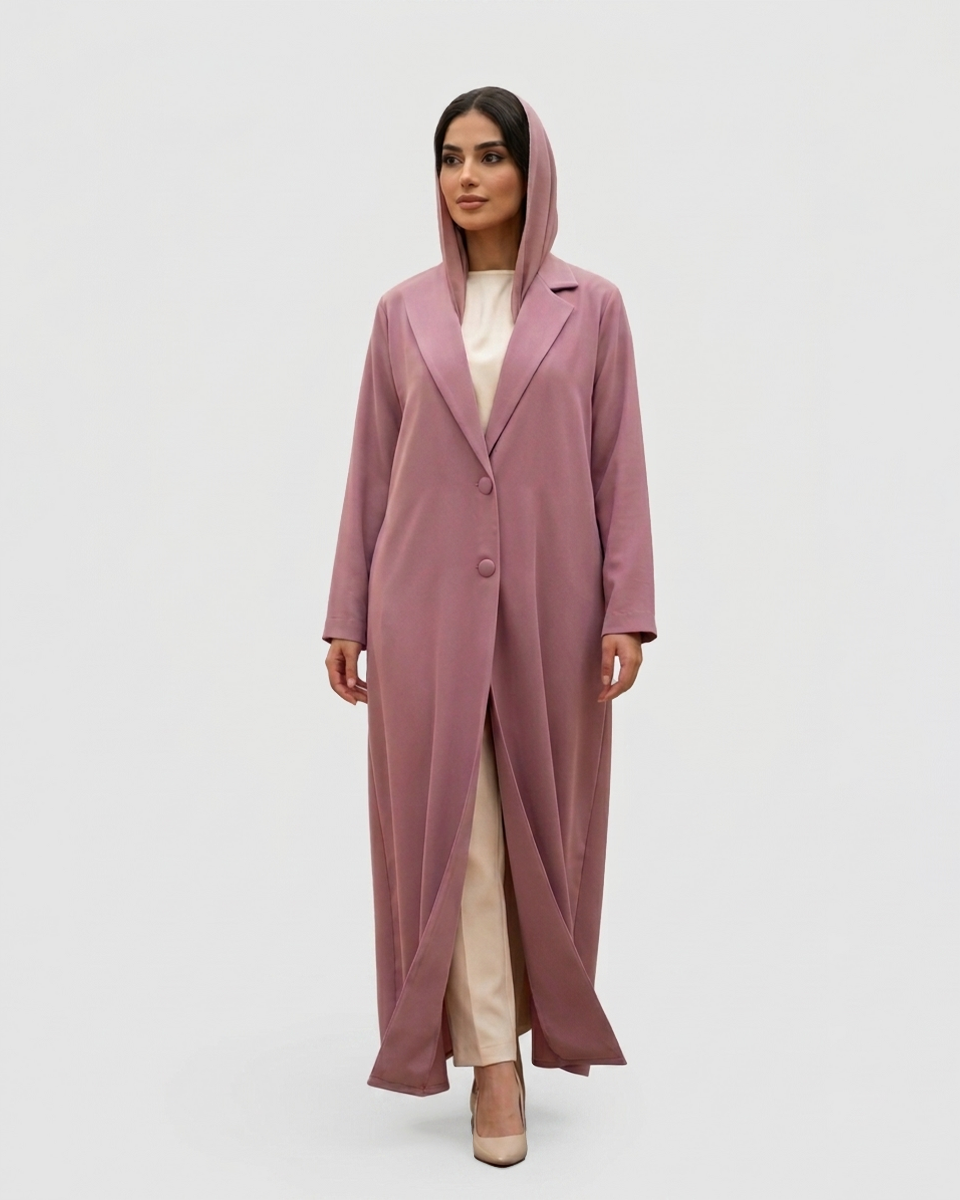 Woman wearing a long pink coat on a white background