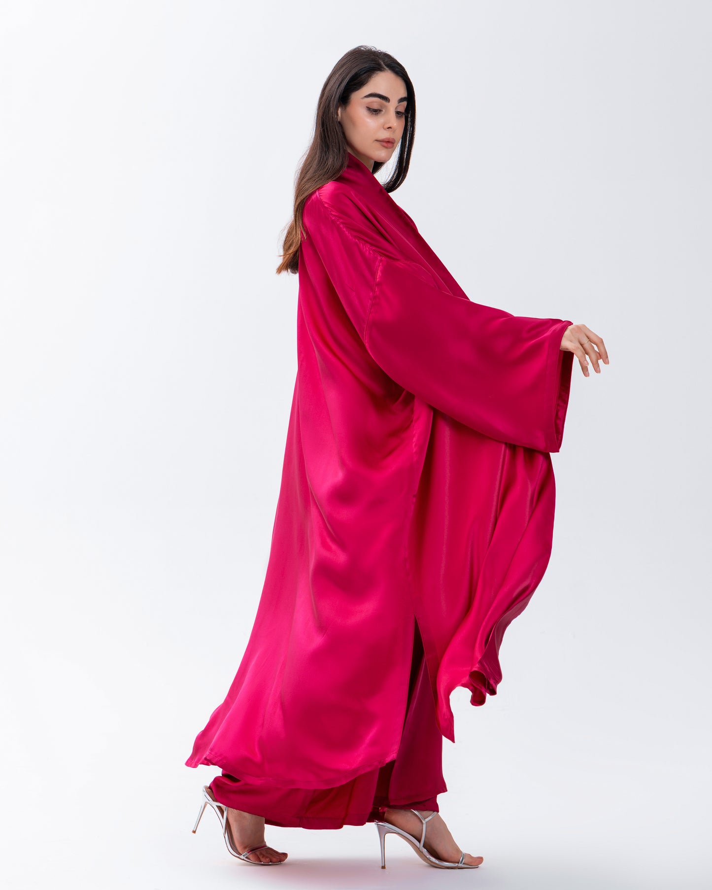 Woman wearing a bright pink outfit on a white background