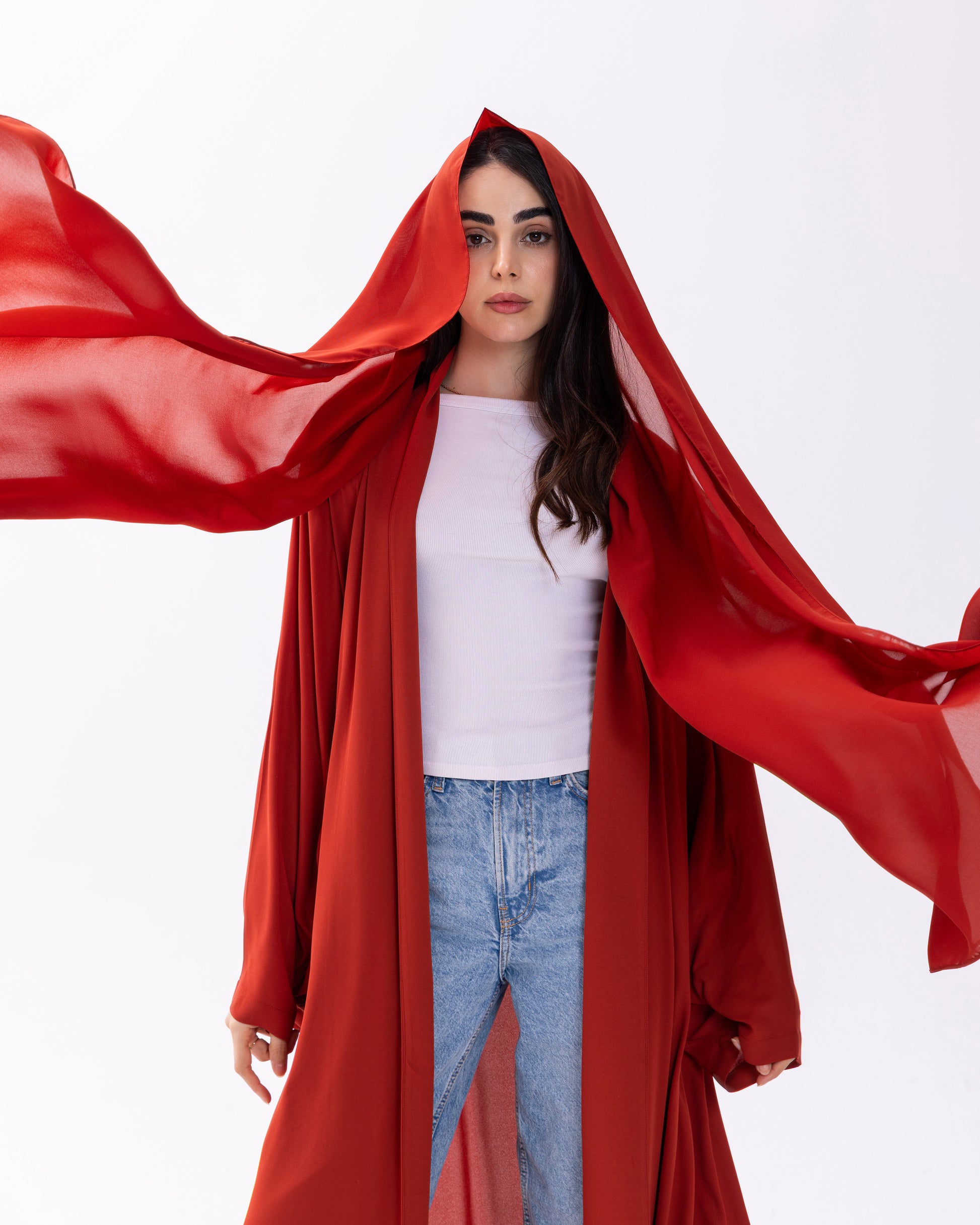 Woman wearing a red hooded garment with a white background