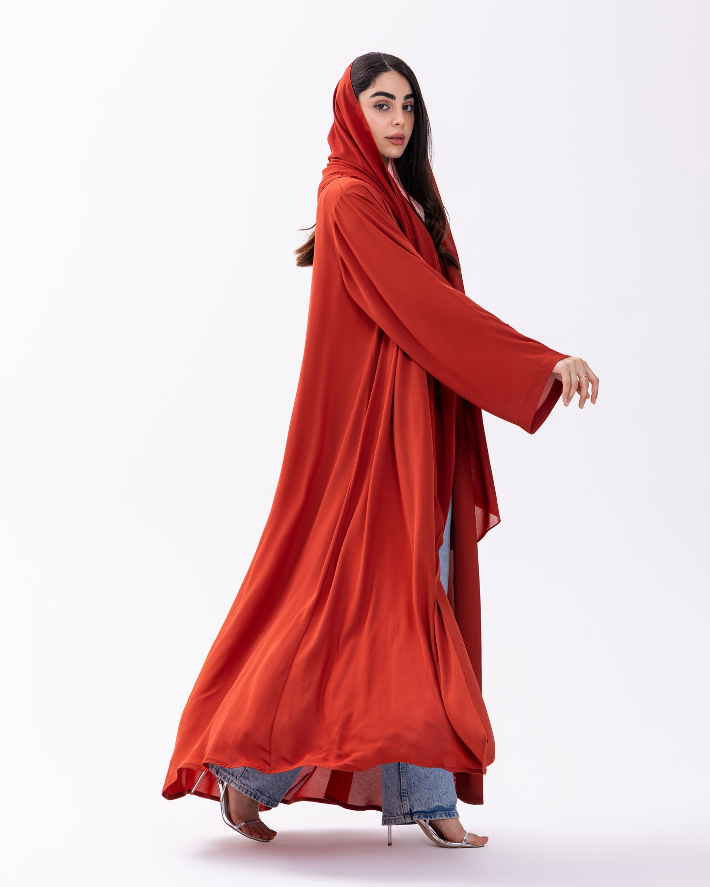 Woman wearing a long red garment on a white background