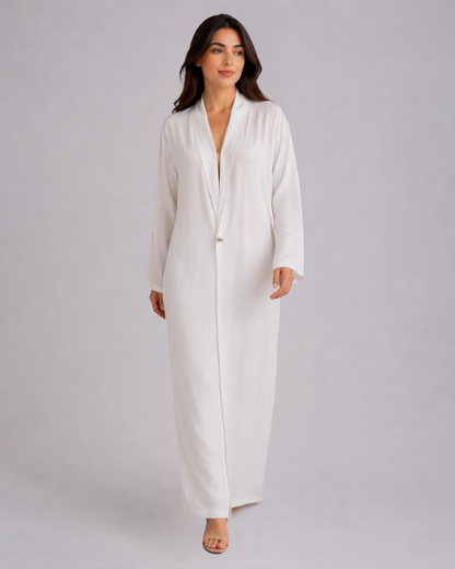 Woman wearing a long white dress against a plain background