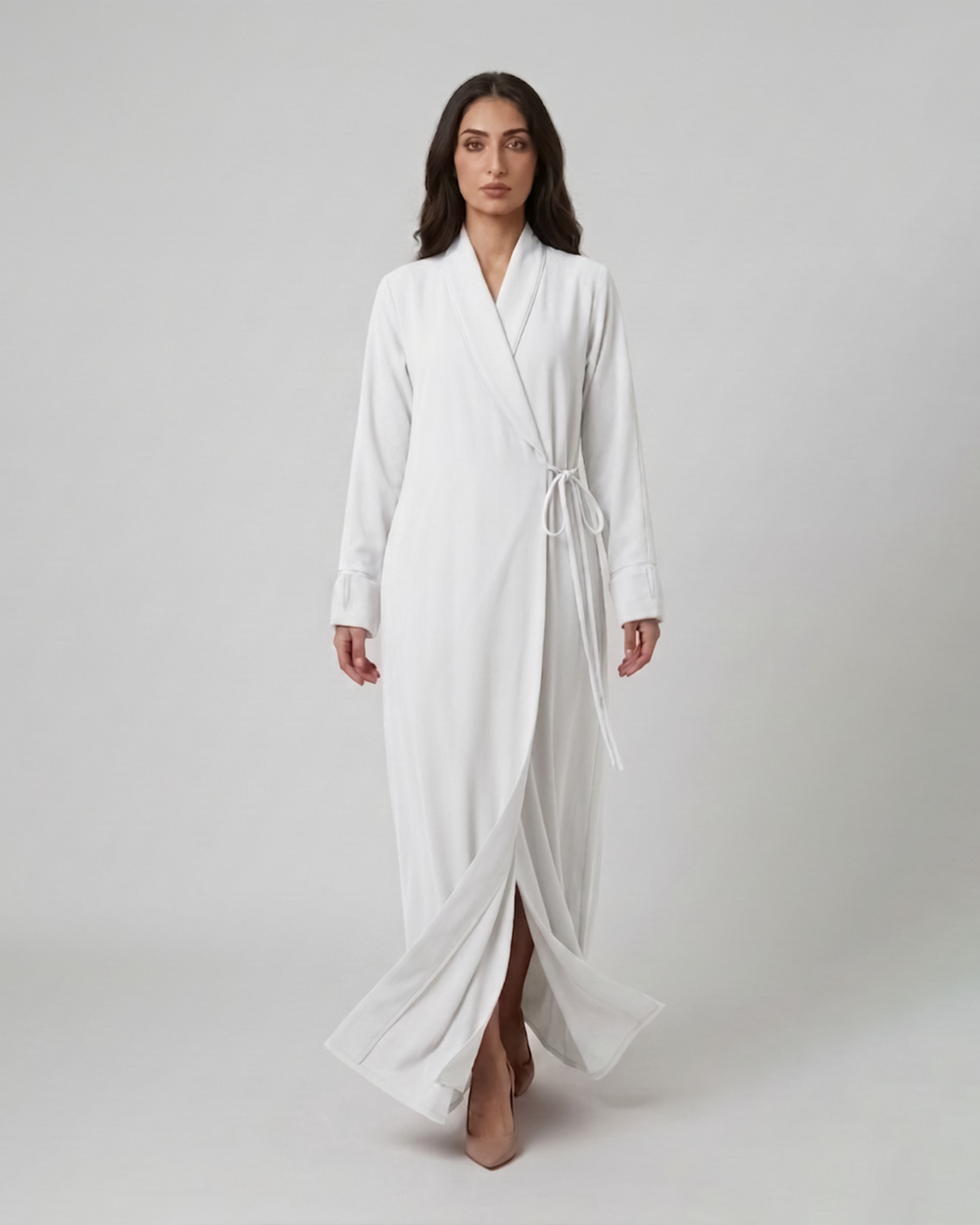 Woman wearing a white robe on a plain background