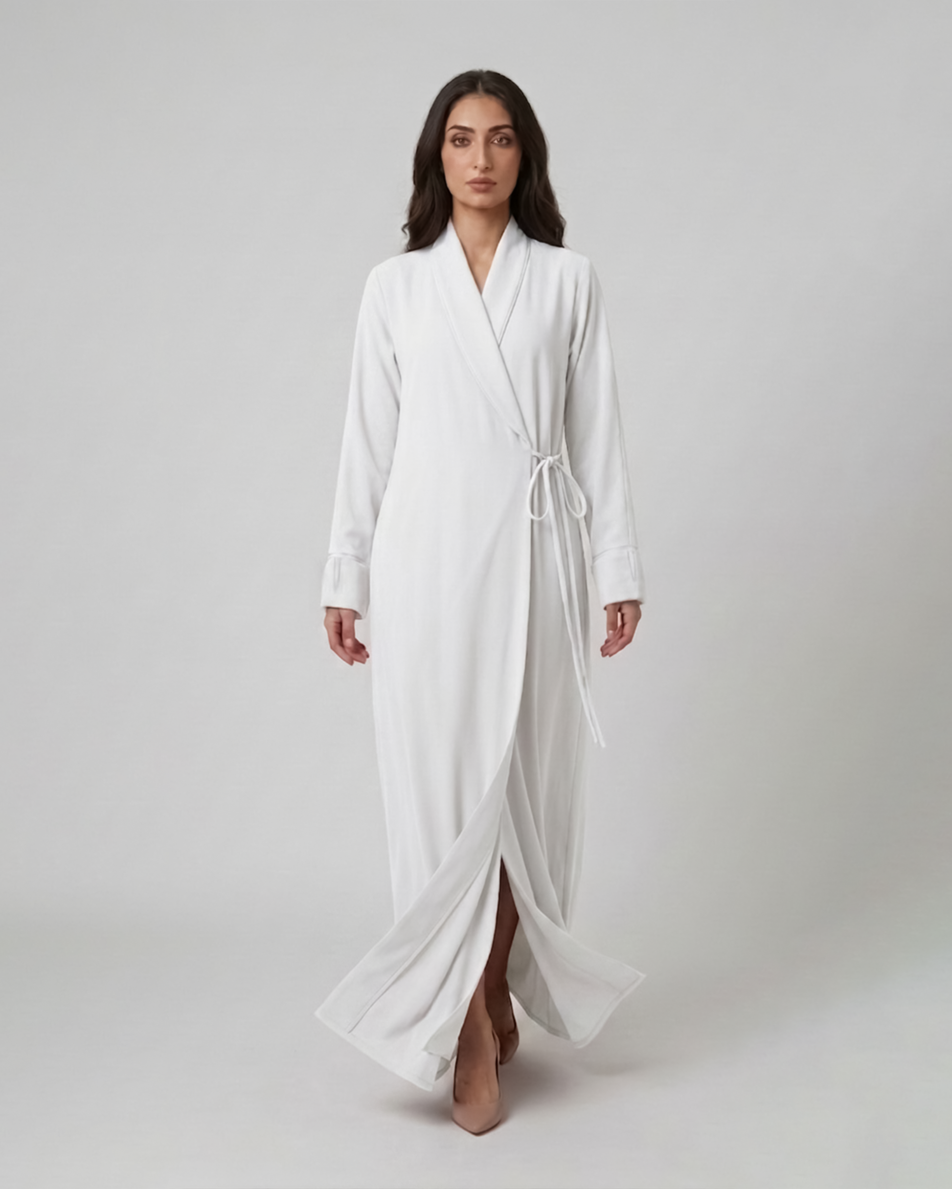 Woman wearing a white robe on a plain background