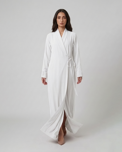 Woman wearing a white robe on a plain background